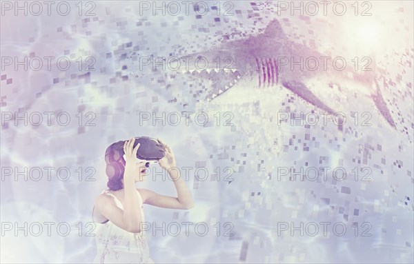 Mixed Race girl using virtual reality goggles watching shark