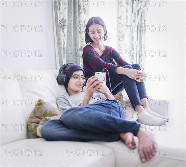 Mixed Race brother and sister watching cell phone