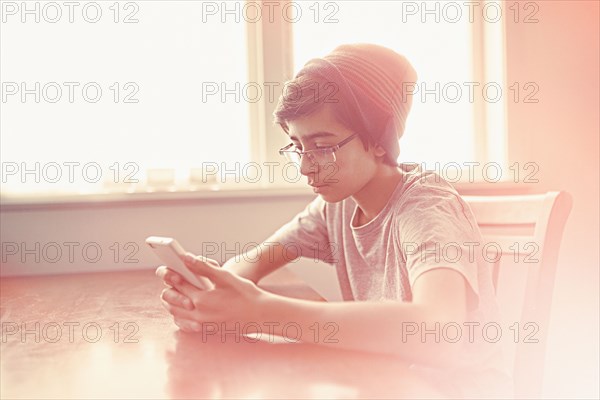 Mixed Race boy texting on cell phone