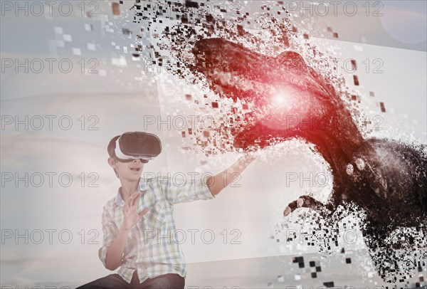 Mixed Race boy using virtual reality goggles watching dinosaur