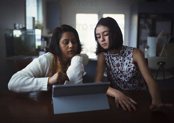 Mother and daughter using digital tablet