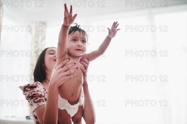 Girl lifting baby brother