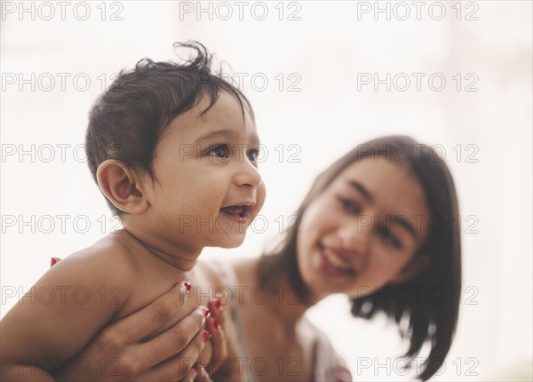 Girl holding smiling baby brother