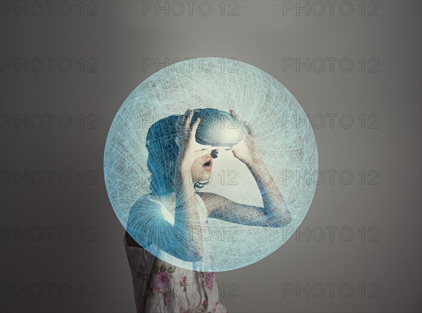 Mixed Race girl wearing virtual reality goggles in blue sphere