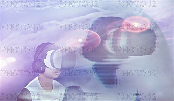 Double exposure of Mixed Race boy wearing virtual reality goggles