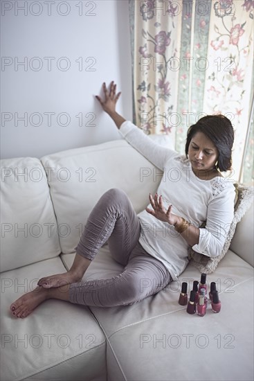 Indian woman watching fingernail polish drying