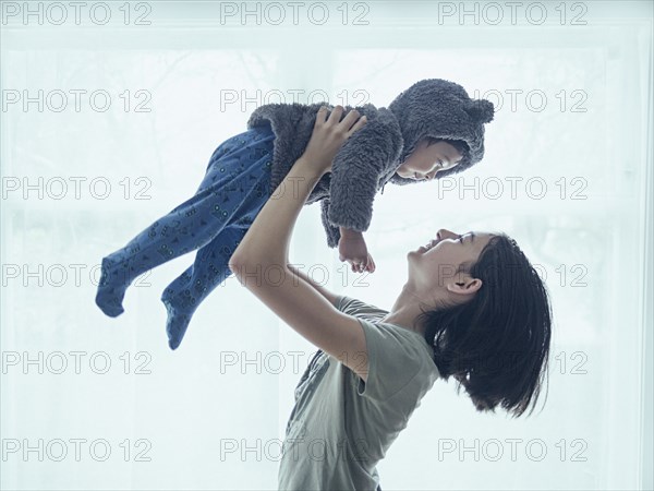 Sister lifting baby brother