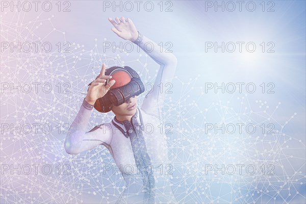 Woman with arms raised using virtual reality helmet