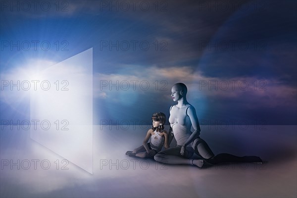 White female cyborg and girl sitting on floor watching virtual screen