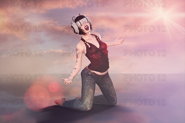 Kneeling woman wearing virtual reality helmet screaming
