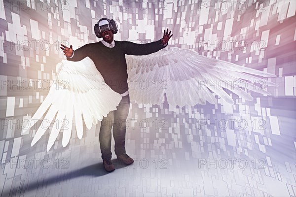 Man with angel wings wearing virtual reality helmet