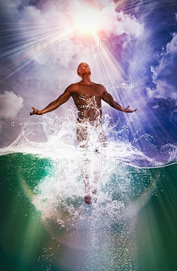 Naked man rising from ocean