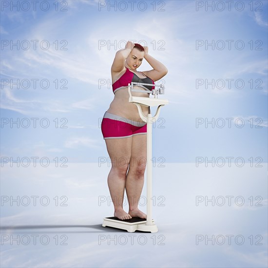Frustrated woman checking weight on scale