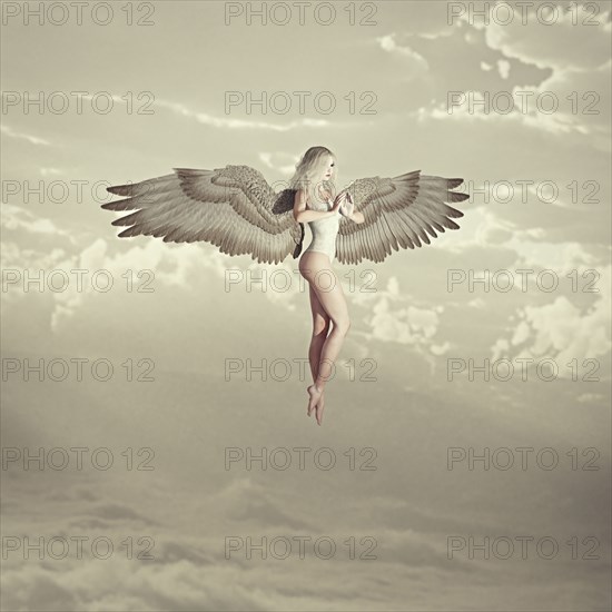 Woman angel flying in clouds