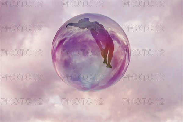 Woman floating in sphere in clouds