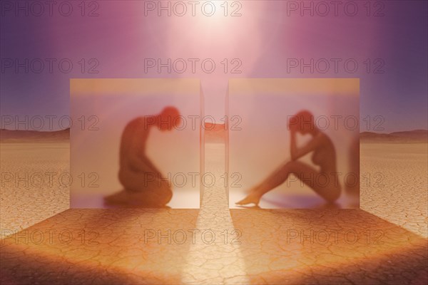 Separated couple in suspended animation in desert