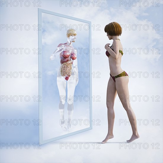 Woman examining reflection of organs in virtual mirror