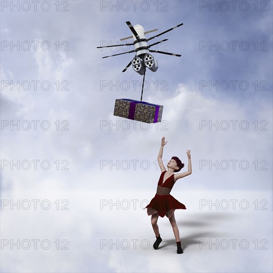 Girl reaching for gift delivered by drone