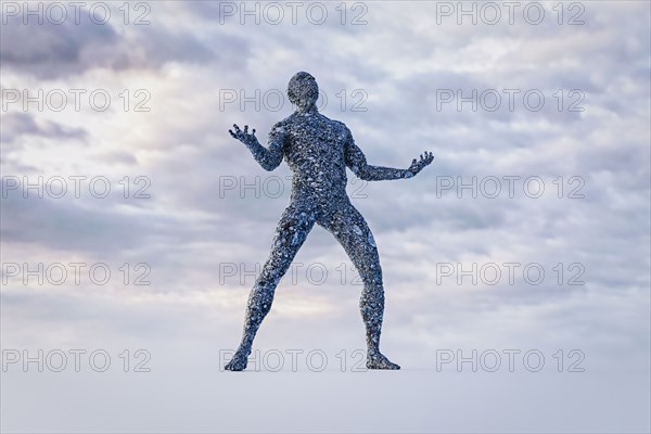 Stone man gesturing anguish under cloudy sky