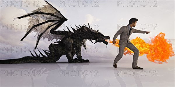 Businessman directing fire breathing dragon