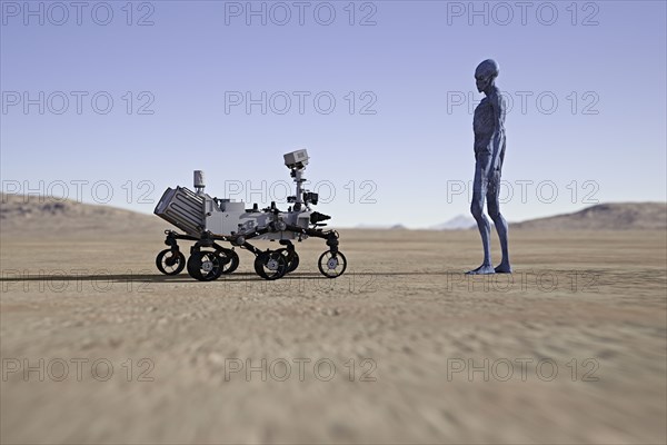 Alien watching small vehicle in desert