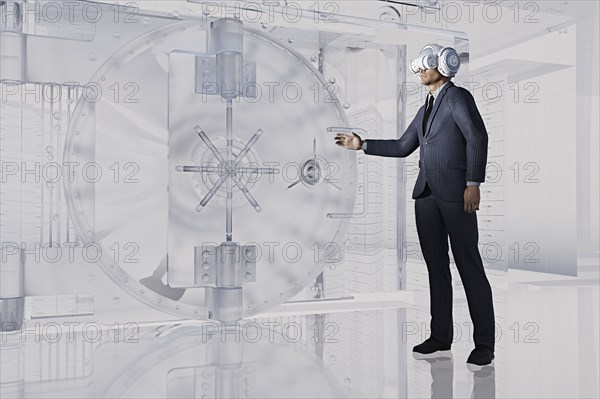 Businessman near vault wearing virtual reality goggles