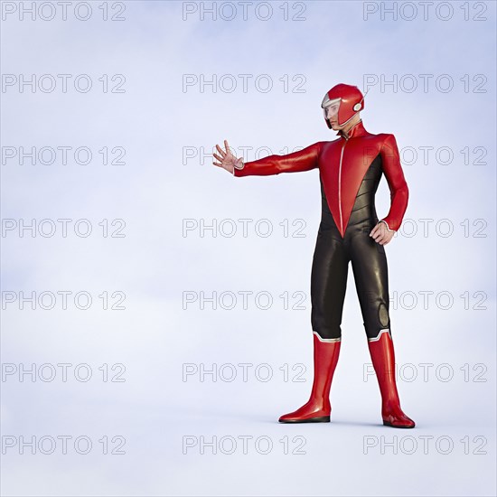 Man wearing superhero costumes gesturing stop