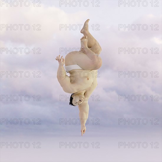 Sumo wrestler balancing upside-down on finger