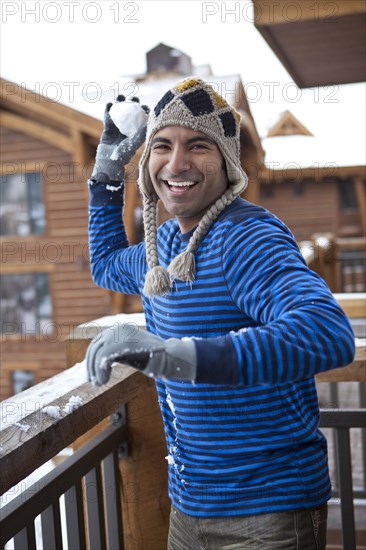 Smiling man throwing snowball