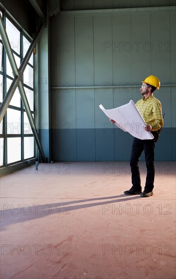 Caucasian architect reviewing blueprints