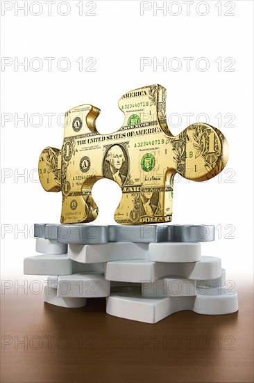 Gold piece of jigsaw puzzle printed with dollars