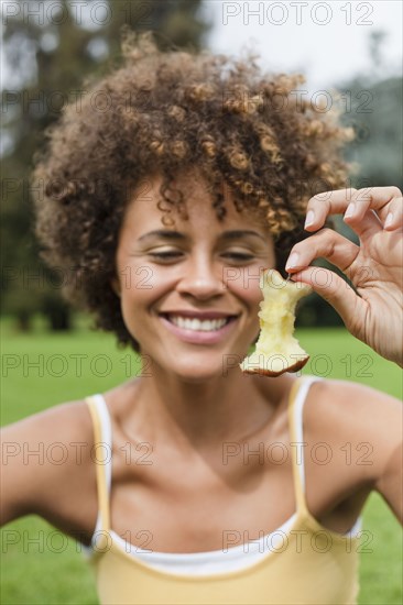 Mixed race woman holding apple core