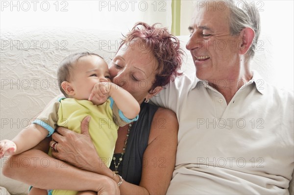 Couple holding baby on sofa