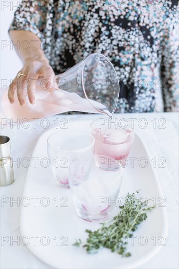 Caucasian woman pouring cocktails on tray