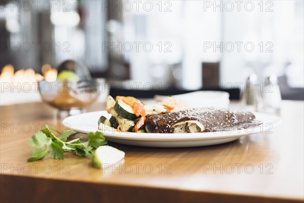 Plate of enchiladas with vegetables and rice