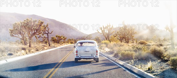 Vintage car driving on desert road