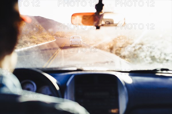 Caucasian man driving car on remote road