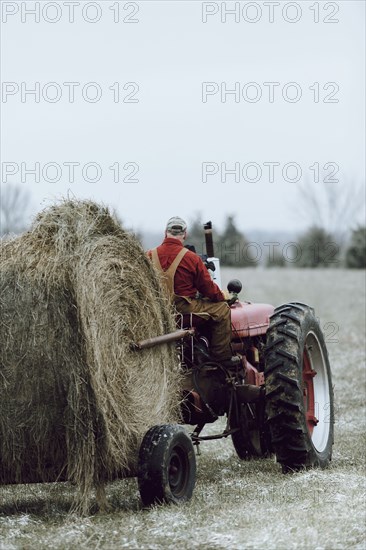 Caucasian farmer driving tractor in field