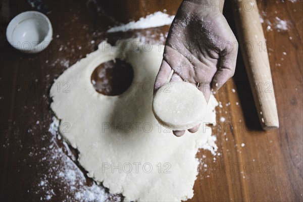 Mixed race baker cutting circle of dough