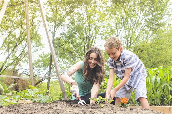 Mother and son planting in garden