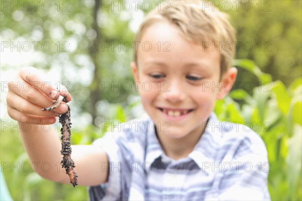 Caucasian boy examining worm