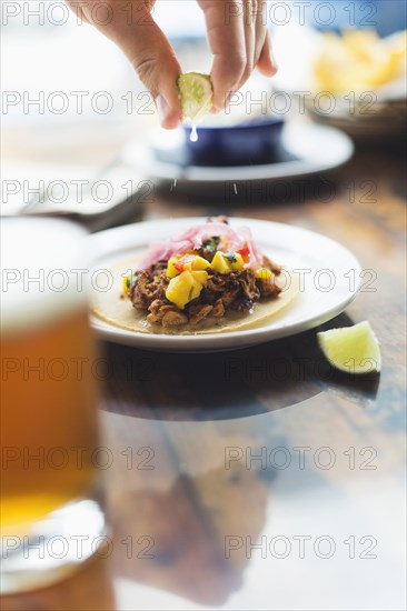 Caucasian man squeezing lime on taco