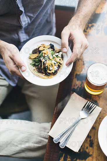 Caucasian man holding taco plate