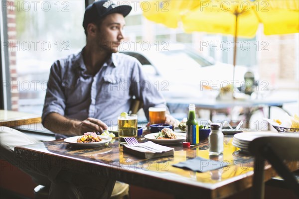 Caucasian man eating tacos in restaurant