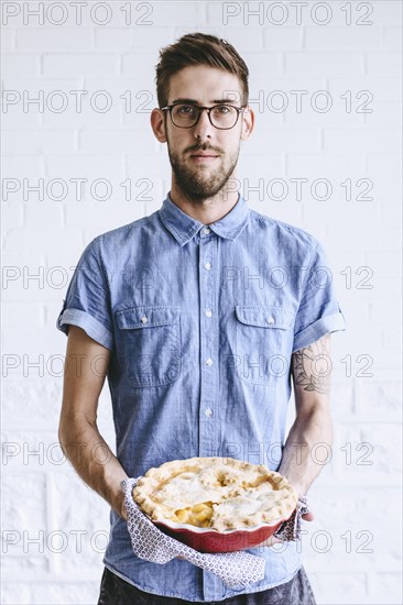 Caucasian man holding peach pie