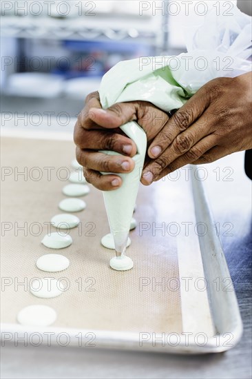 Close up of baker piping cookie dough