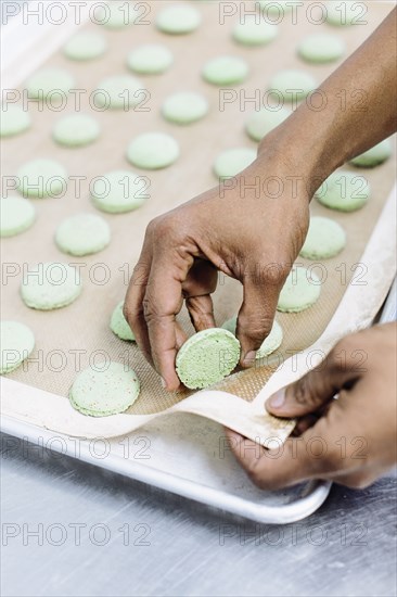 Close up of baker peeling cookies from tray