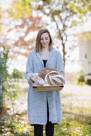 Caucasian woman holding bread outdoors