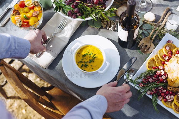 Caucasian man setting platter of soup on outdoor table