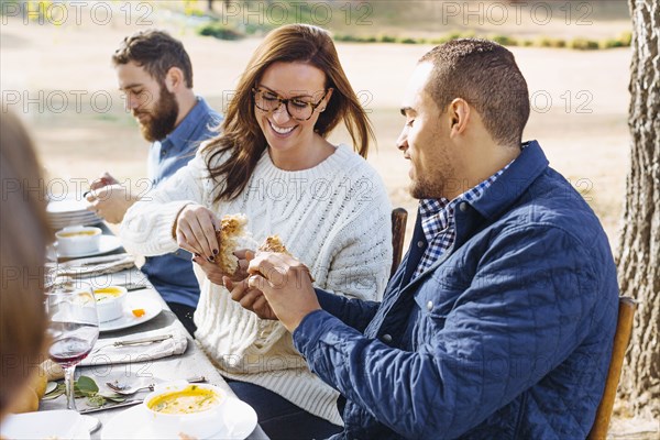 Couple breaking bread at outdoor table